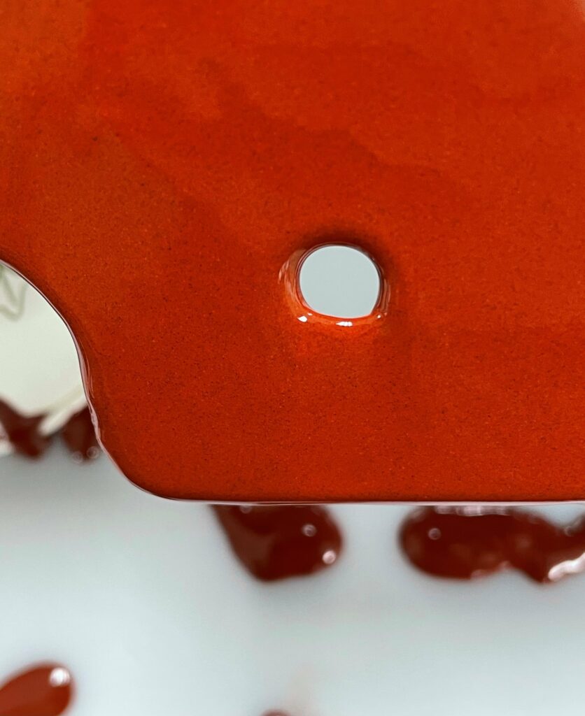 Devcon Brushable Ceramic Red applied to metal around a fixture hole